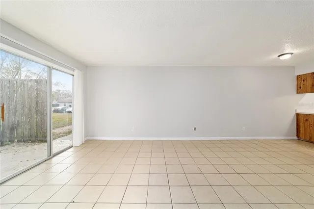 a view of a livingroom with an empty space and a kitchen
