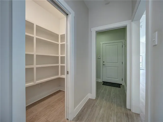a view of a hallway with wooden floor and closet