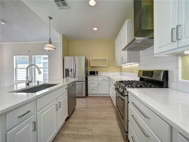 a kitchen with white cabinets and appliances