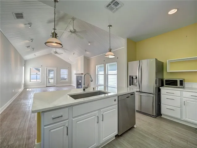 a kitchen with kitchen island white cabinets and refrigerator