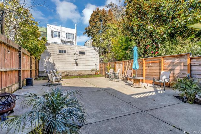 a view of a patio with couches and table under an umbrella