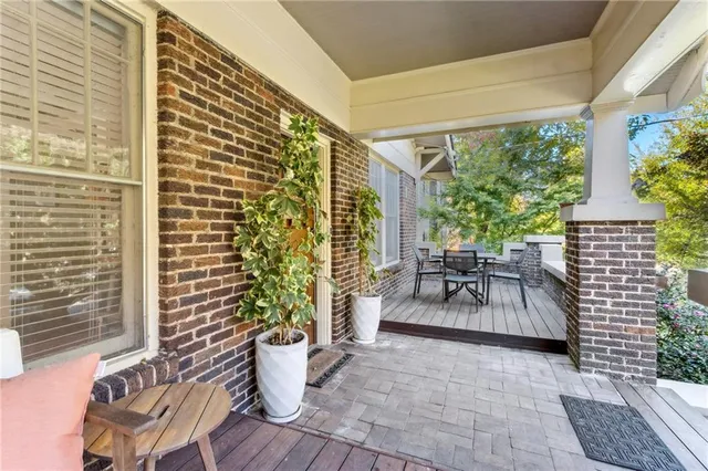 a balcony with chairs and potted plants