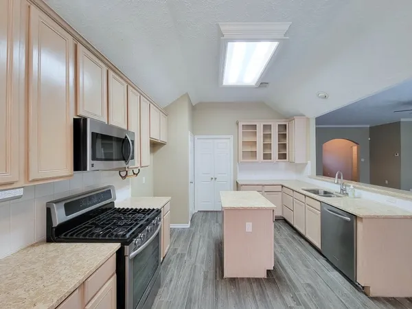 a kitchen with stainless steel appliances granite countertop a stove a sink and a refrigerator