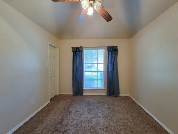 an empty room with windows and closet