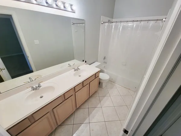 a spacious bathroom with a double vanity sink and a mirror