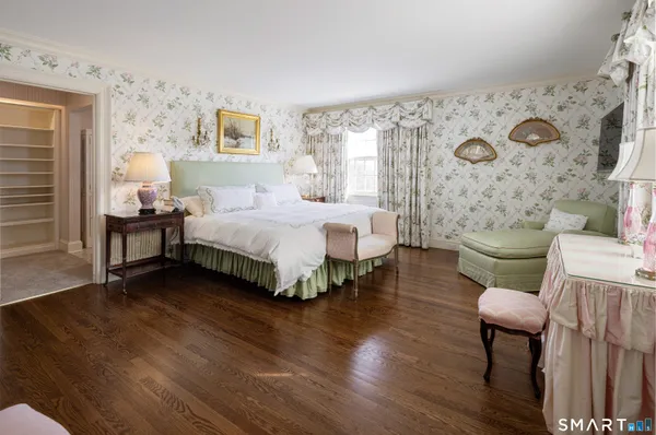 a spacious bedroom with two beds and painting on the wall