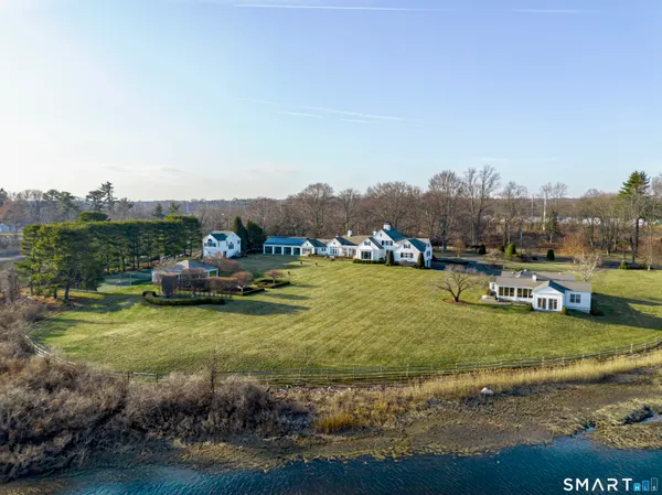 a front view of a house with a garden and lake view