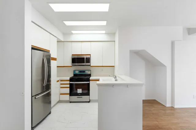 a kitchen with stainless steel appliances a refrigerator stove and microwave