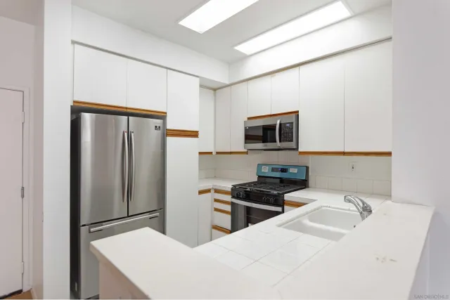 a kitchen with stainless steel appliances a refrigerator and a stove top oven
