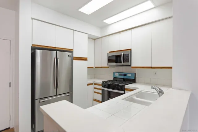 a kitchen with stainless steel appliances a refrigerator stove and microwave