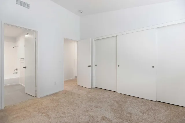 a bathroom with a granite countertop sink a toilet a mirror and bathtub