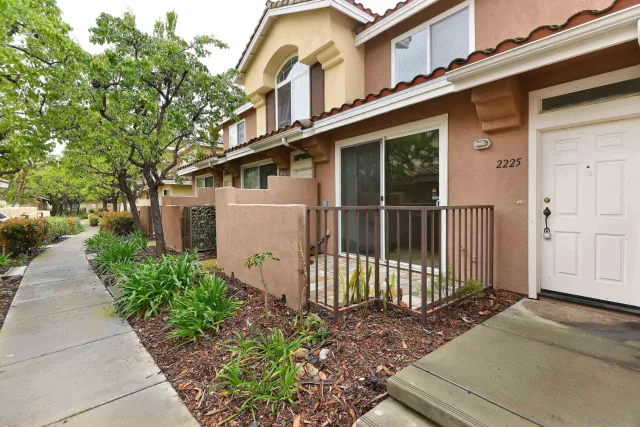 a view of a house with a small yard and plants