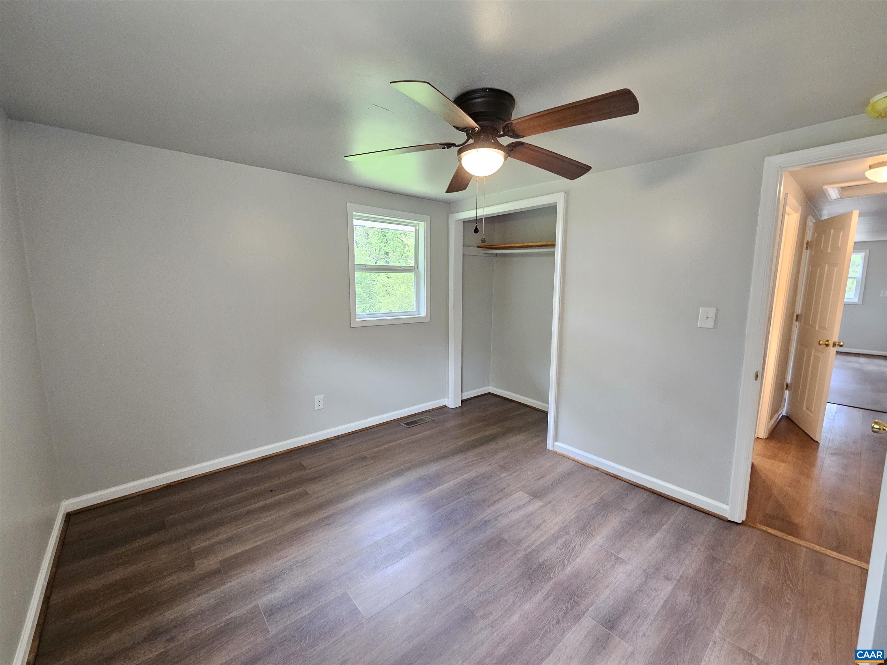 5290 Dixie Hill Road Buckingham, VA 23921 - Photo 14 of 24 an empty room with wooden floor fan and windows