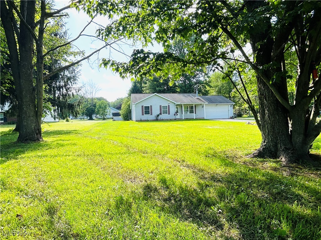 5636 Laskey Road Rome, OH 44085 - Photo 3 of 29 View of green lawn featuring a garage