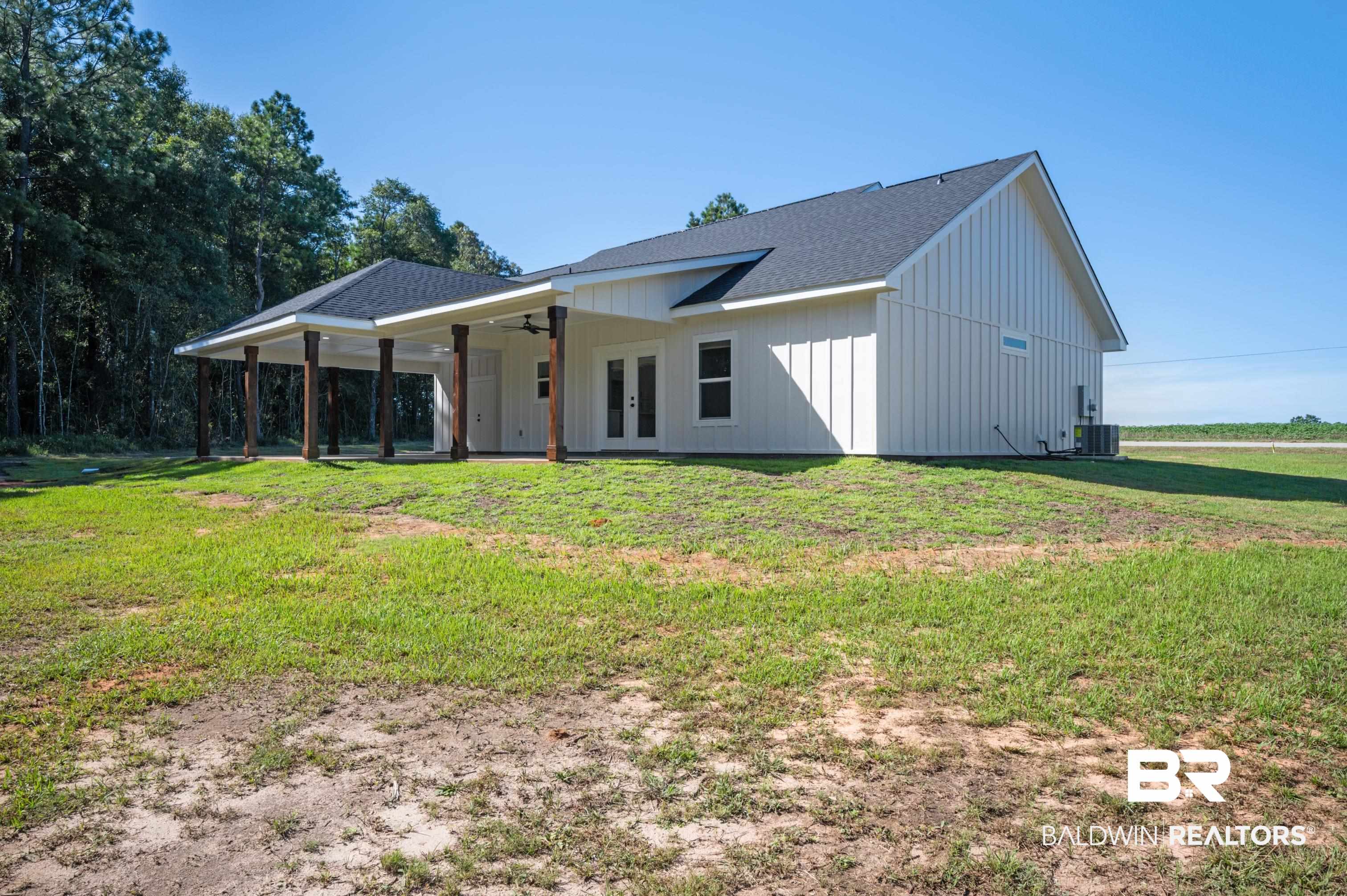 12100 Lott Road Chunchula, AL 36521 - Photo 20 of 21 Rear view of property featuring a yard, ceiling fan, and cooling unit