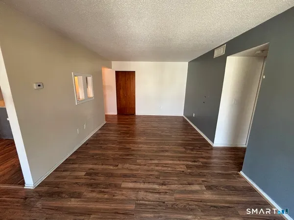 a view of an empty room with wooden floor