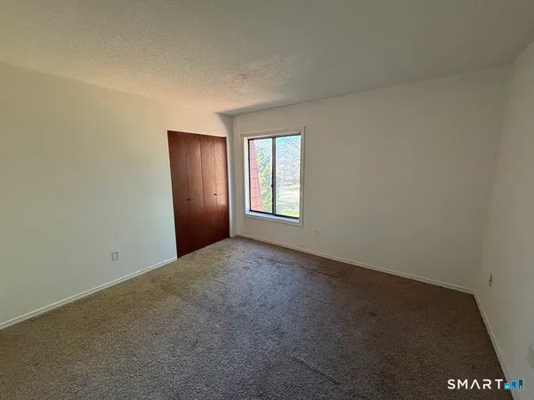 an empty room with windows and closet