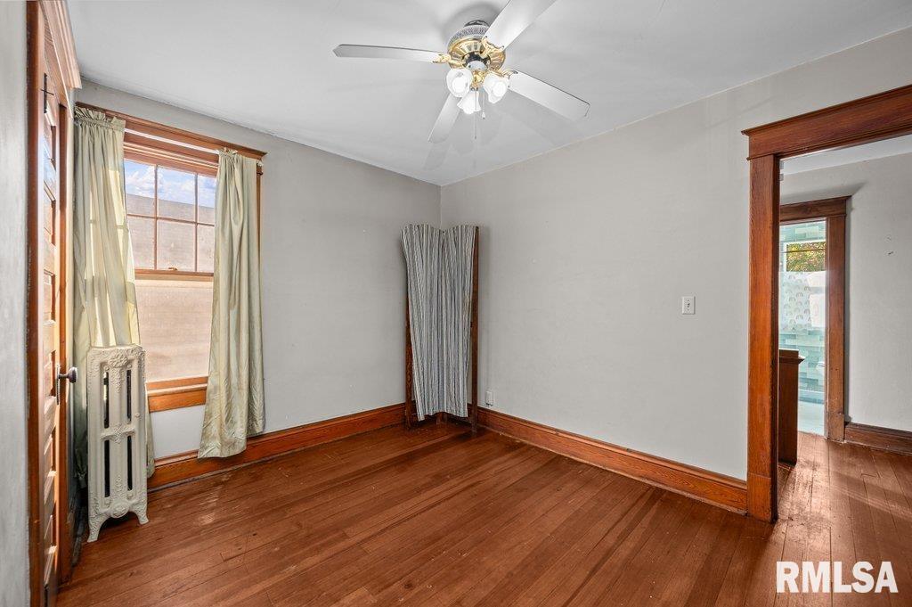 2105 15th Street Moline, IL 61265 - Photo 17 of 29 an empty room with wooden floor and a ceiling fan
