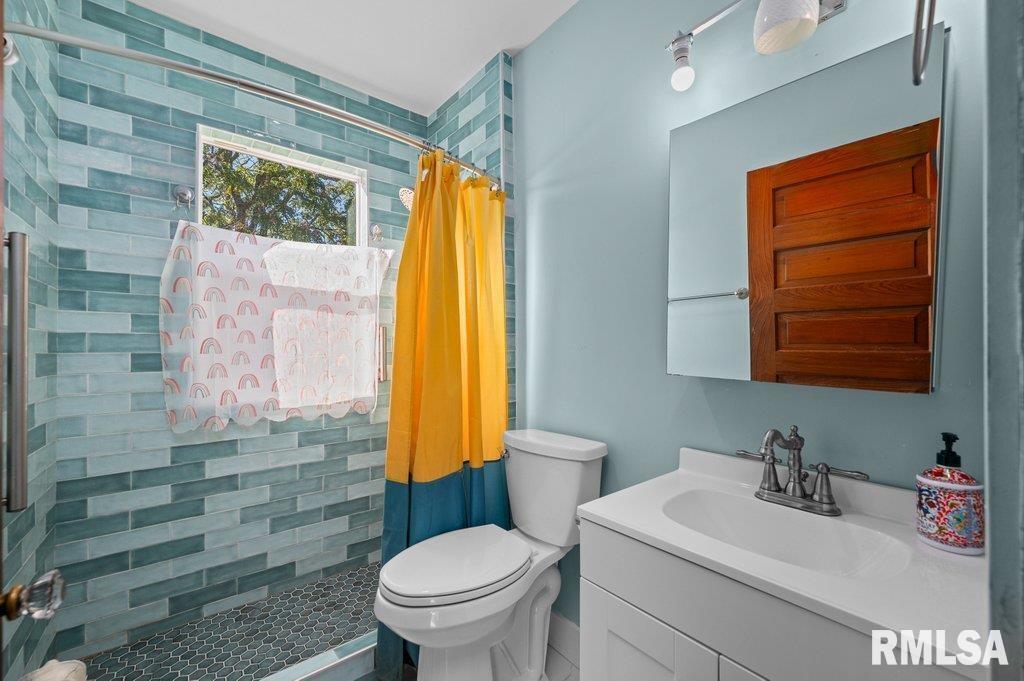 2105 15th Street Moline, IL 61265 - Photo 22 of 29 a bathroom with a sink a toilet and a mirror