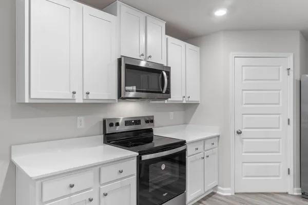 a kitchen with a sink and wooden floor