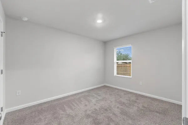 a bedroom with a bed a couch and potted plant on the dresser