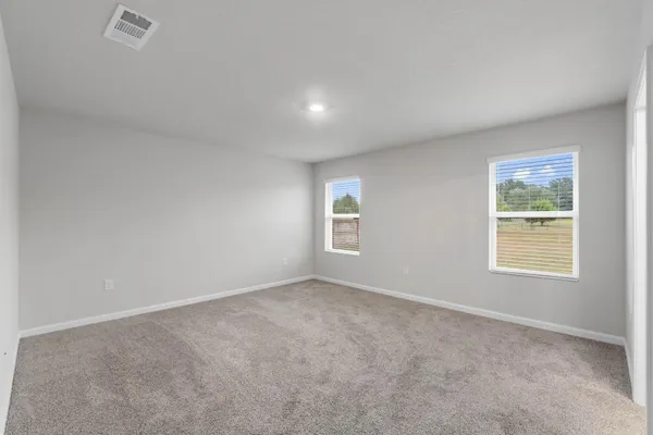 a room with a bed and windows