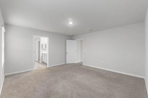 a spacious bedroom with a bed a couch and a potted plant