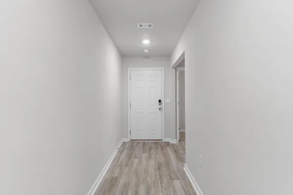 a view of a room with wooden floor and a bathroom