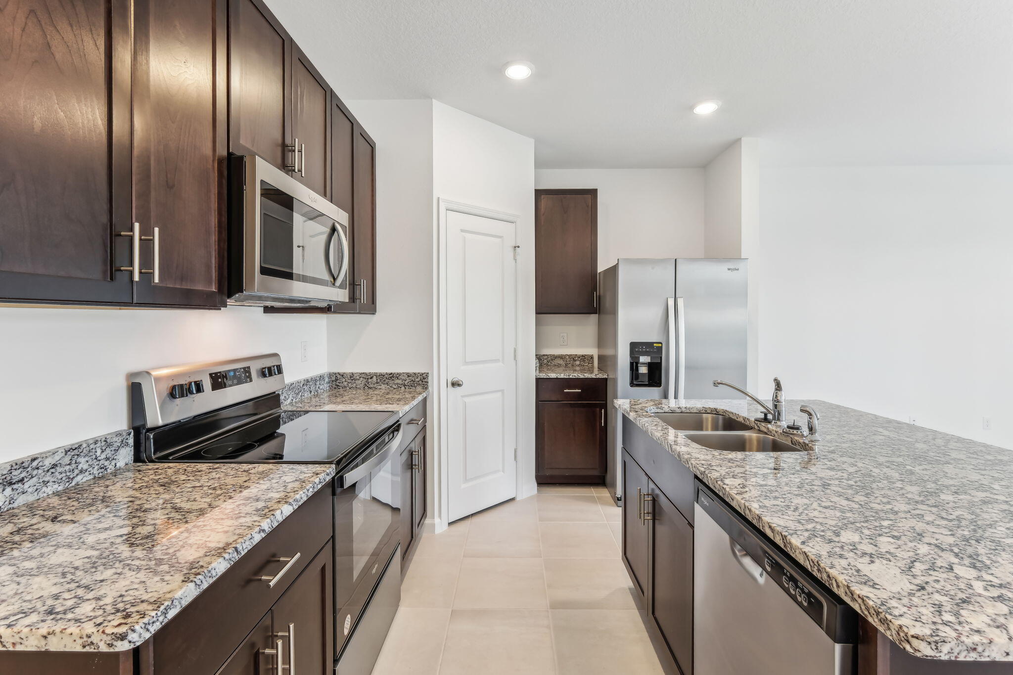 676 Salisbury Circle Fort Pierce, FL 34982 - Photo 13 of 31 a kitchen with granite countertop stainless steel appliances and wooden cabinets