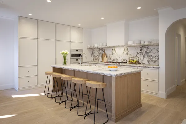 a kitchen with kitchen island granite countertop a sink and a refrigerator