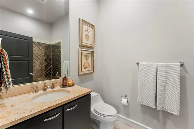 a bathroom with a granite countertop sink toilet and mirror