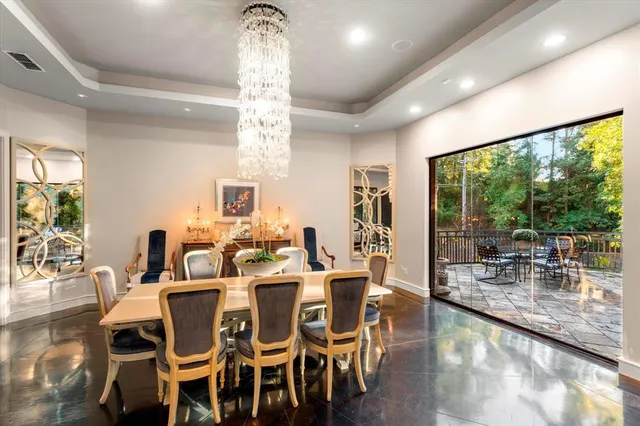 a dining room with furniture a chandelier and wooden floor