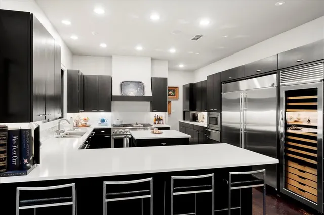 a kitchen with kitchen island a sink stainless steel appliances and cabinets