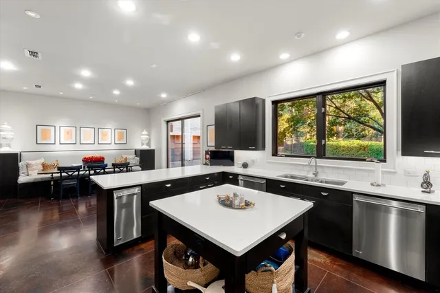 a kitchen with a stove a sink dishwasher a dining table and chairs with wooden floor