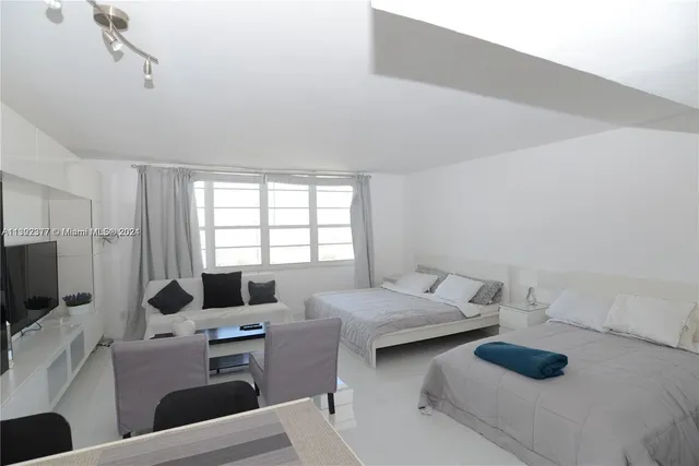 a bedroom with furniture and a flat screen tv