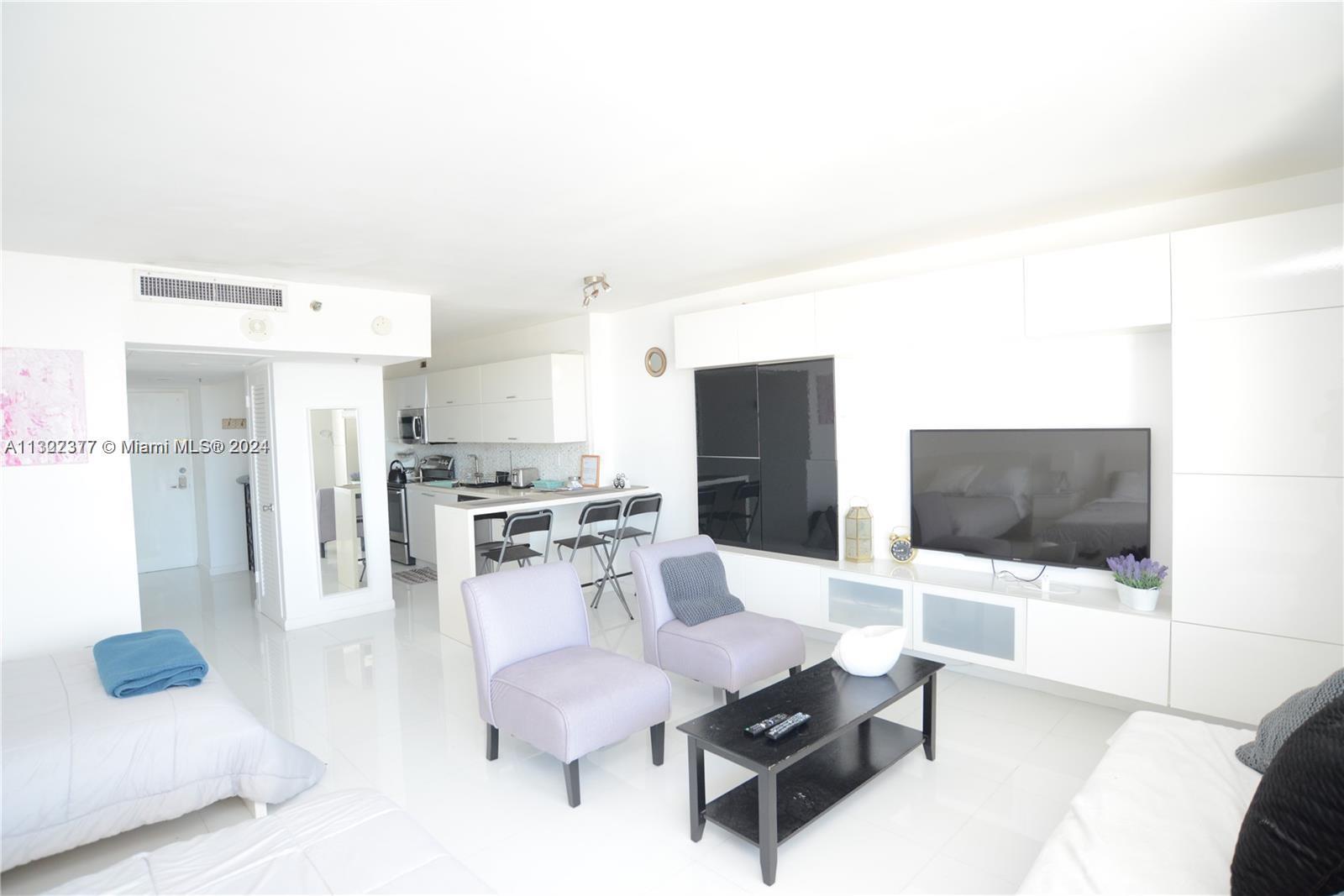 100 Lincoln Road, Unit 1605 Miami Beach, FL 33139 - Photo 4 of 20 a living room with furniture and a flat screen tv