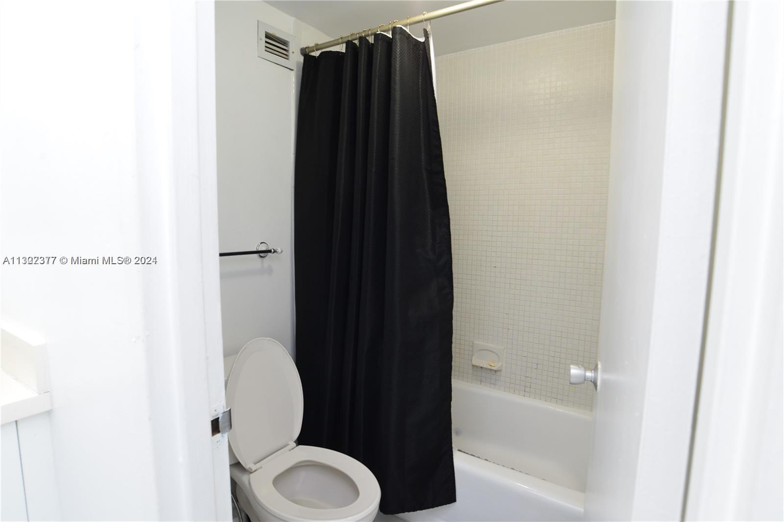 100 Lincoln Road, Unit 1605 Miami Beach, FL 33139 - Photo 9 of 20 a bathroom with a toilet and a shower curtain