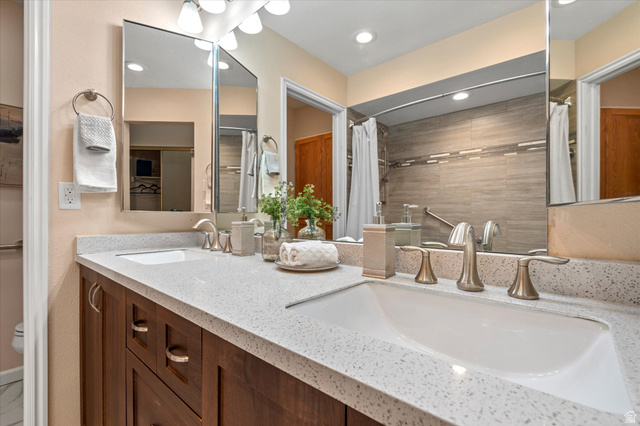 888 East 6895 South Midvale, UT 84047 - Photo 14 of 54 Updated bathroom featuring a dual-sink vanity with solid-surface countertops, modern fixtures, and abundant storage.