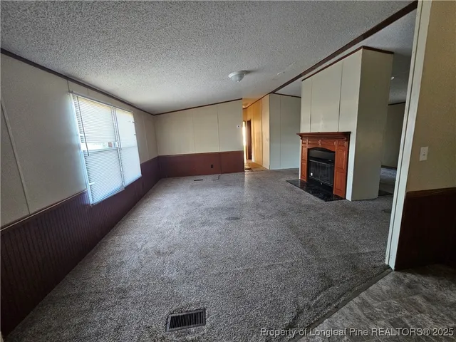 an empty room with windows and fireplace