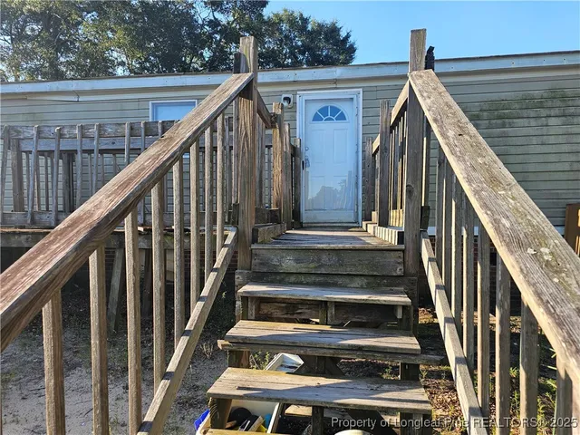 a view of wooden staircase with railing and white walls