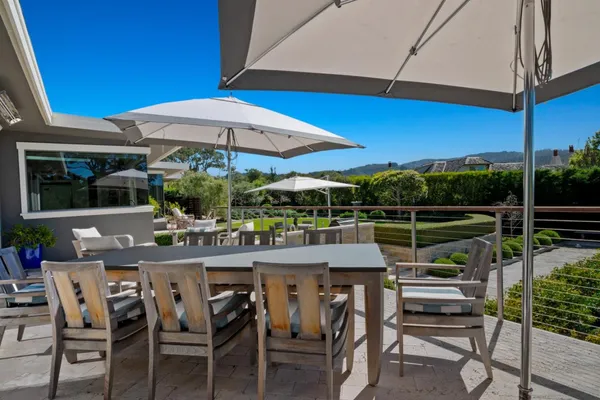 a view of a patio with a table chairs and a umbrella