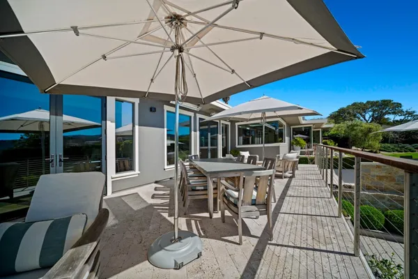 a view of a patio with table and chairs under an umbrella