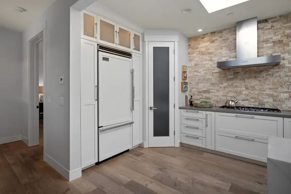 a hallway with cabinets and wooden floor