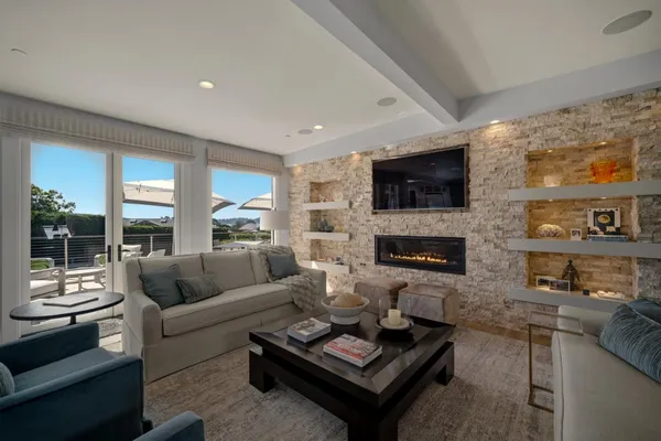 a living room with furniture a flat screen tv and a fireplace