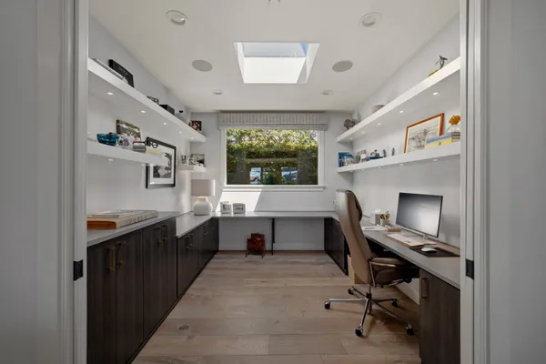 a view of a workspace with furniture and a window