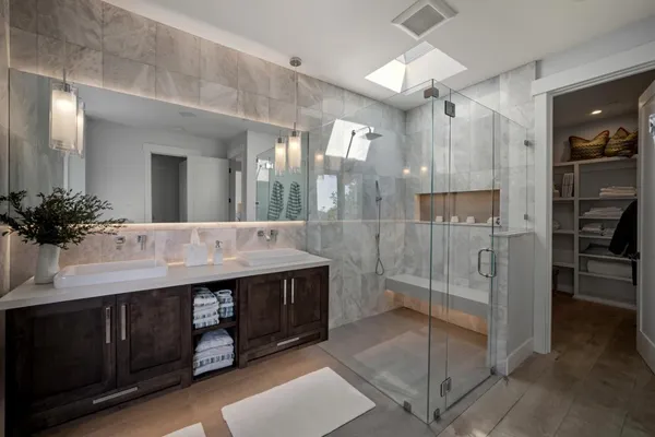 a bathroom with a double vanity sink mirror and shower