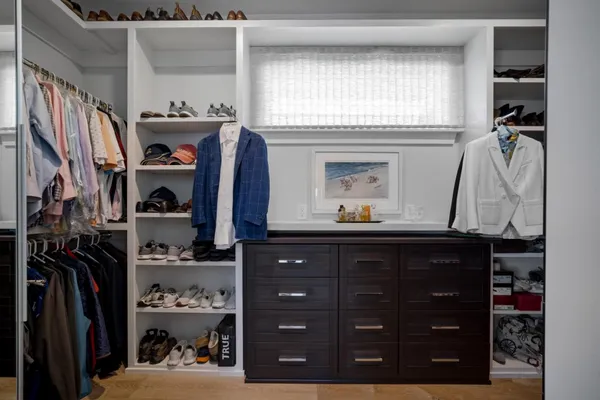 a view of walk in closet with clothes and shoes