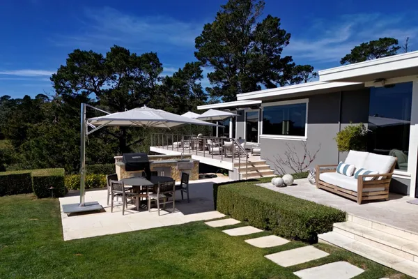 a view of a house with backyard and sitting area