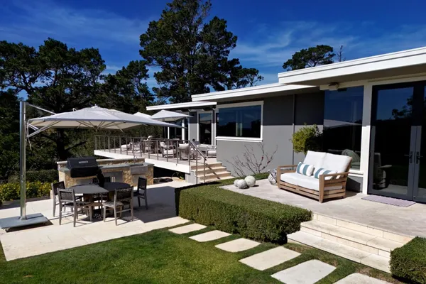 a view of a house with backyard sitting area and garden