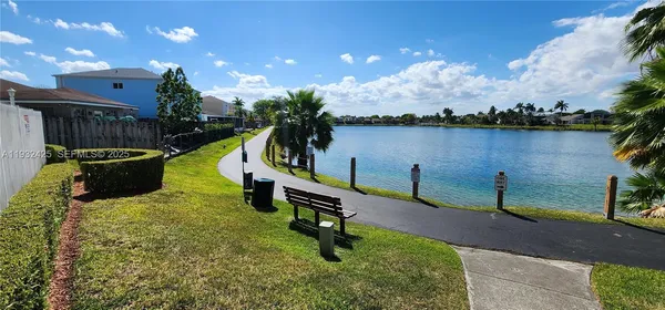 a park view with a bench and plants